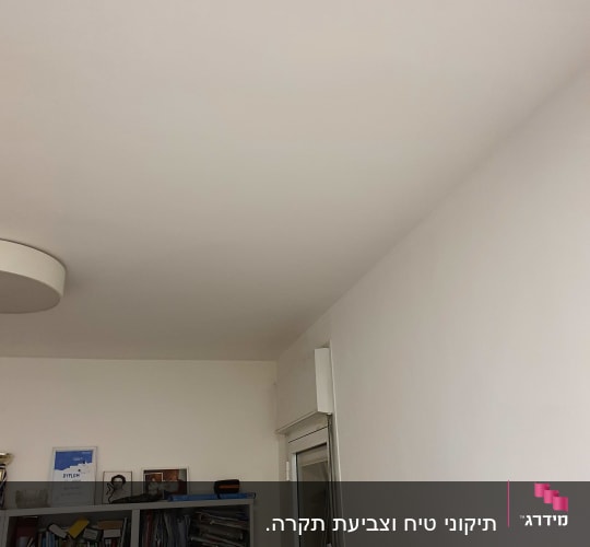 מדף עם ספרים וציור צבעוני על הקיר